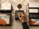 A hand adjusts a copper control in a modular content system that transforms source cards into article, audio and visual assets.