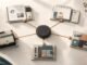 An overhead editorial still life showing a central AI hub connected to five distinct workstations for research, planning, content, software and communication.